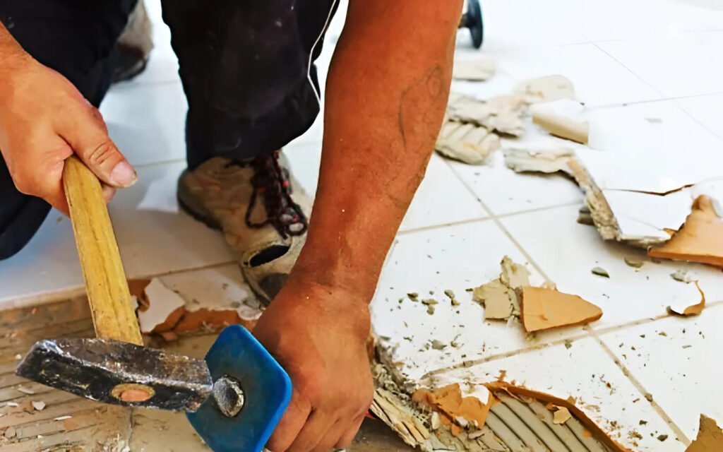 Dùng đục và búa để gỡ gạch lát nền 