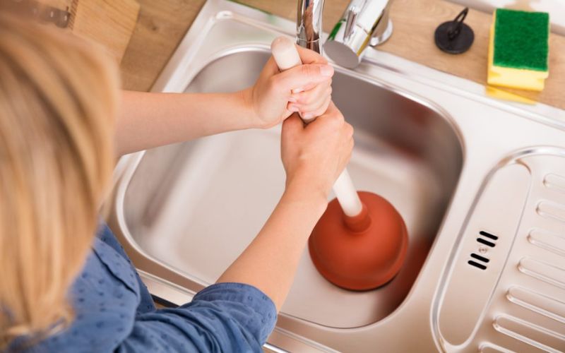 Dùng pittong chuyên dụng đẩy rác tắc nghẽn 